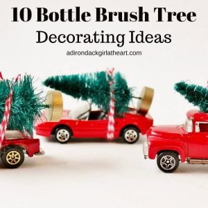 3 red toy cars with bottle brush trees tied to the top