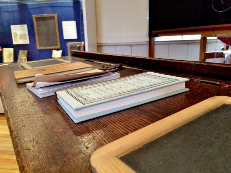 school books and chalkboard on antique desk