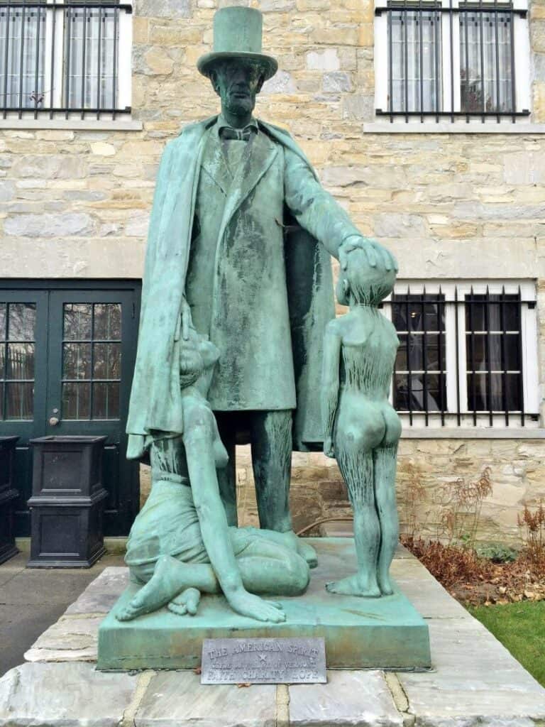 Green statue of Lincolnn with 2 children