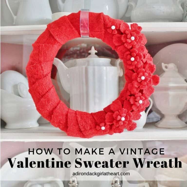 Red wool wreath on white ironstone background