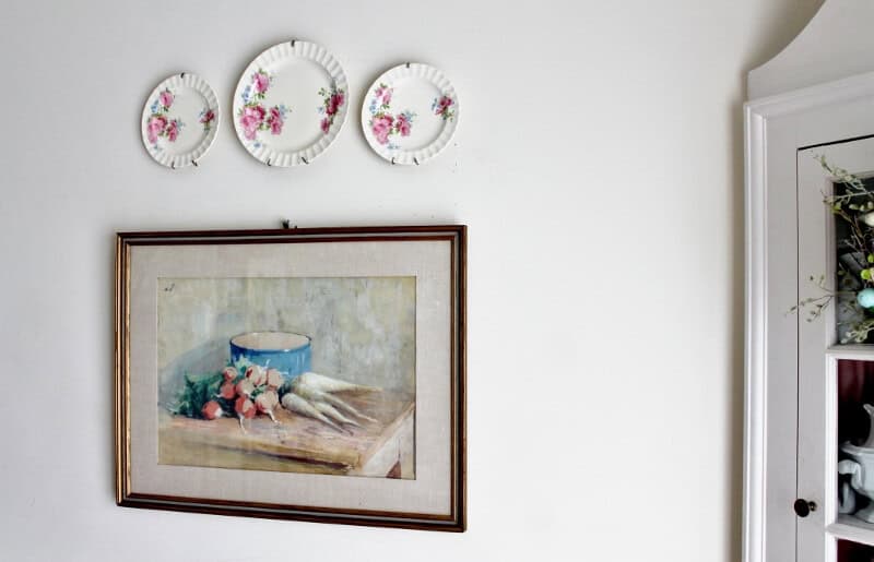 Painting of vegetables on a table with a blue pot