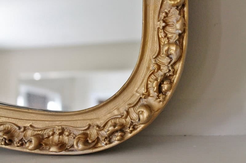 Close up of painted gold ornate mirror
