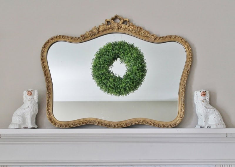 ornate gold mirror with green wreath and staffordshire dogs