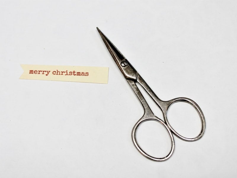 scissors next to merry christmas tag
