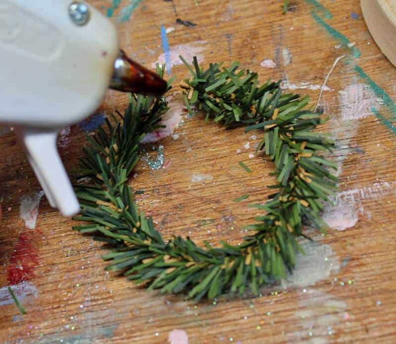 Shaping pine pipe cleaner into a circle and gluing closed