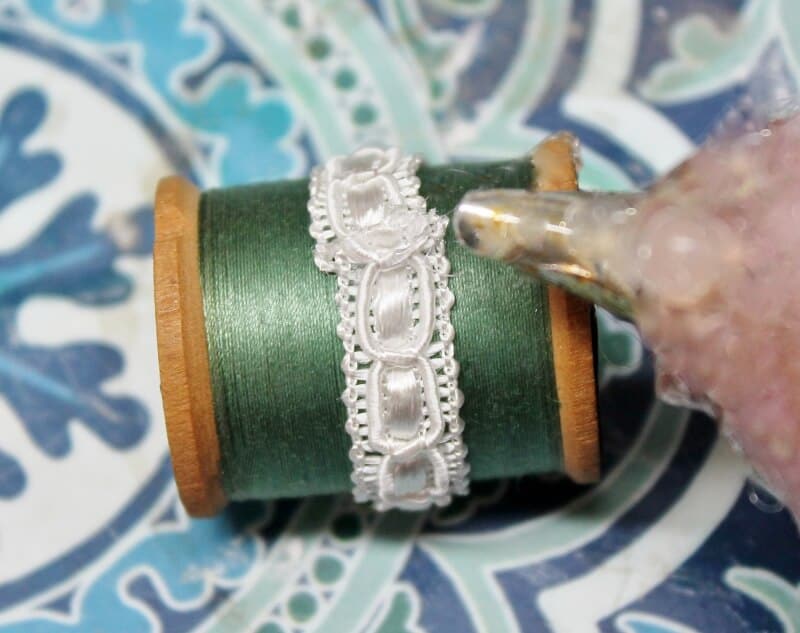 Hot glue ivory ribbon/trim to green thread
