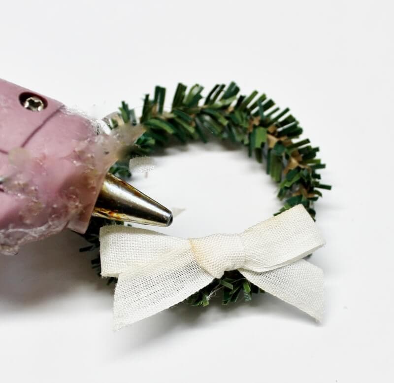 Gluing bows to the wreaths