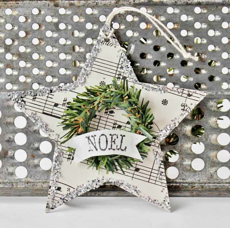 Vintage star-shaped ornament with mini wreath and 'Noel' banner for holiday decor.