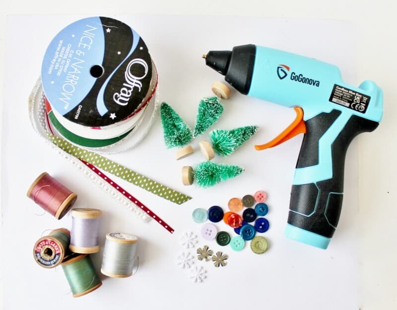 Materials: glue gun, ribbon, spools of thread, buttons and bottle brush trees
