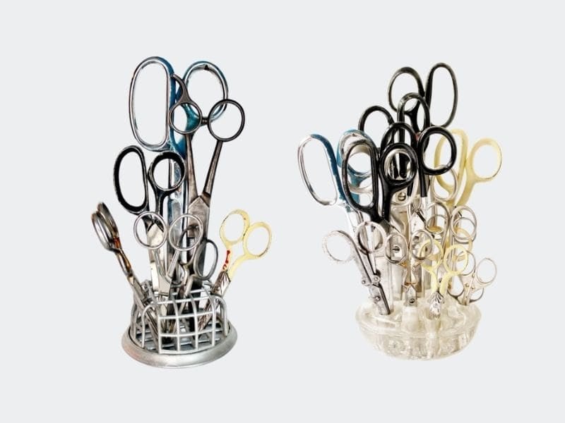 lots of scissors in two different vintage flower frogs: one metal, one clear glass