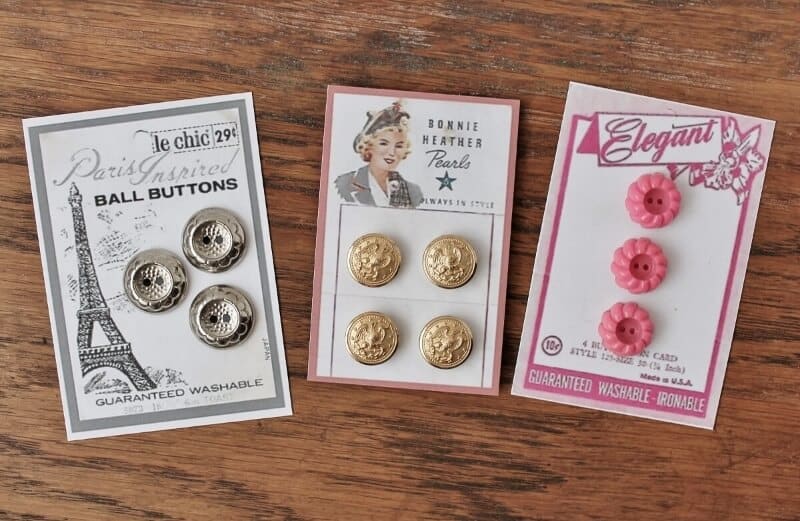 3 cards of buttons on wooden background