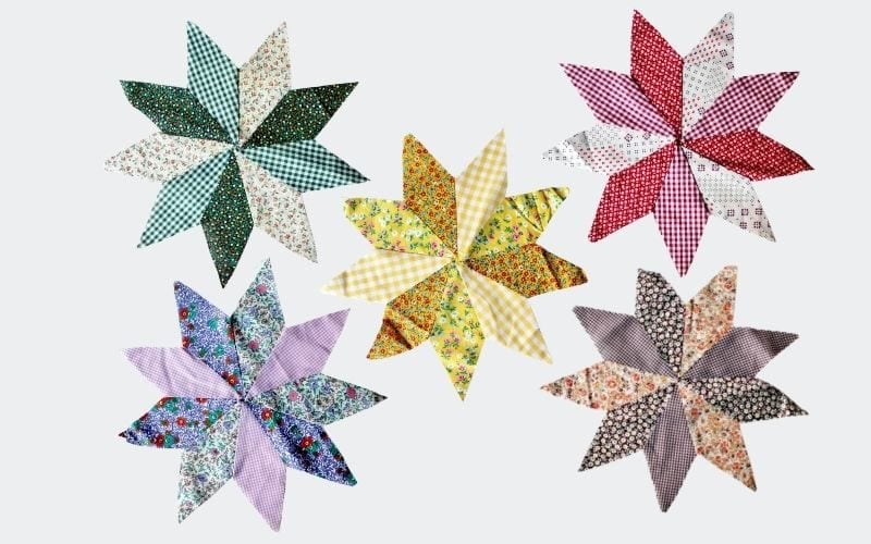 colorful quilted star shapes: yellows, blues, reds, greens, and browns