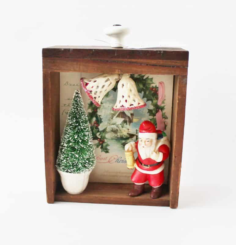 A Christmas diorama with a santa figure and bottle brush tree