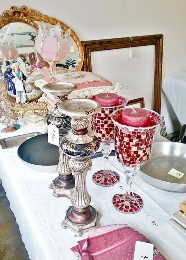 Table filled with vintage and antique homegoods at a garage sale