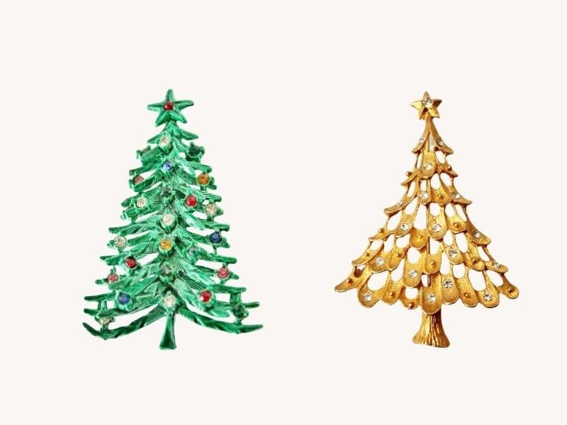 Two vintage christmas tree pins one green the other gold with a pearl