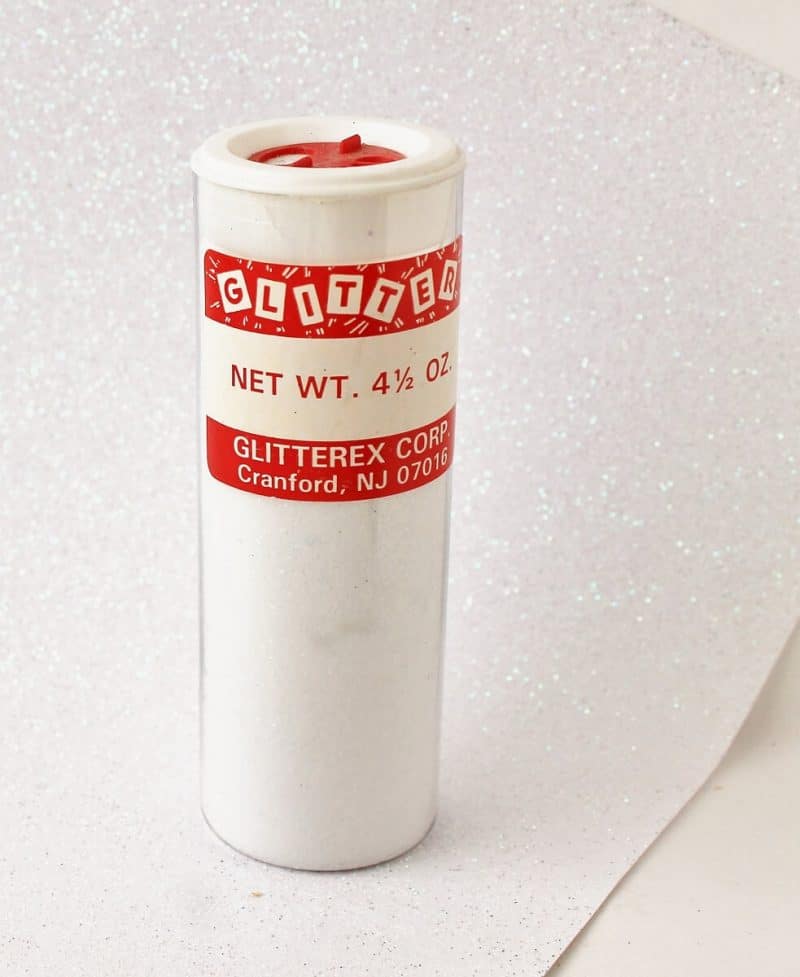 container of glitter and glitter scrapbook paper