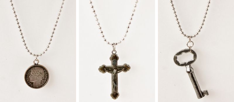 three pendant necklaces: french coin, crucifix, skeleton key