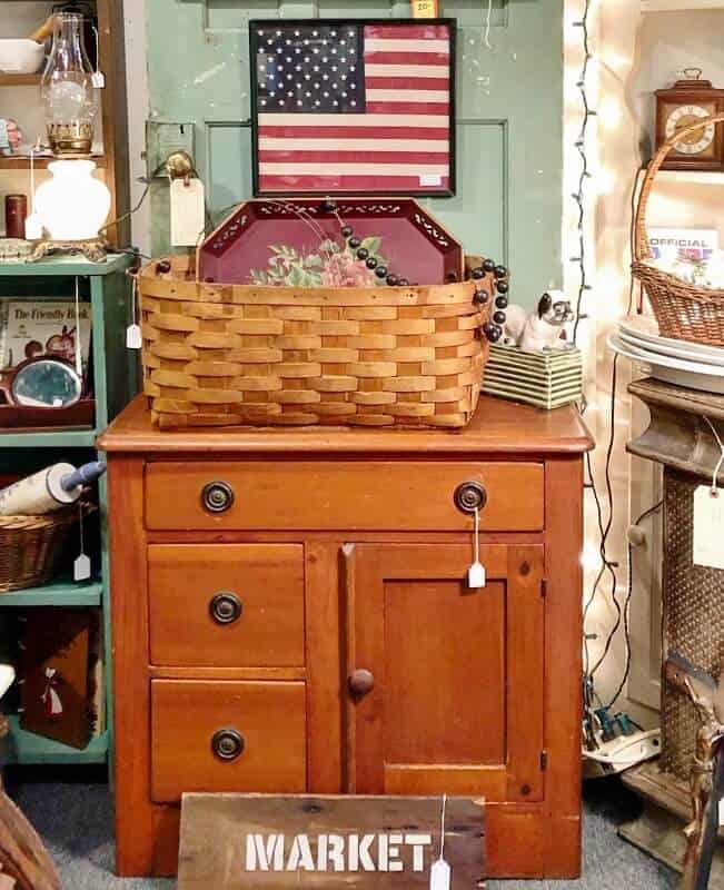 vintage commode with basket and framed flag