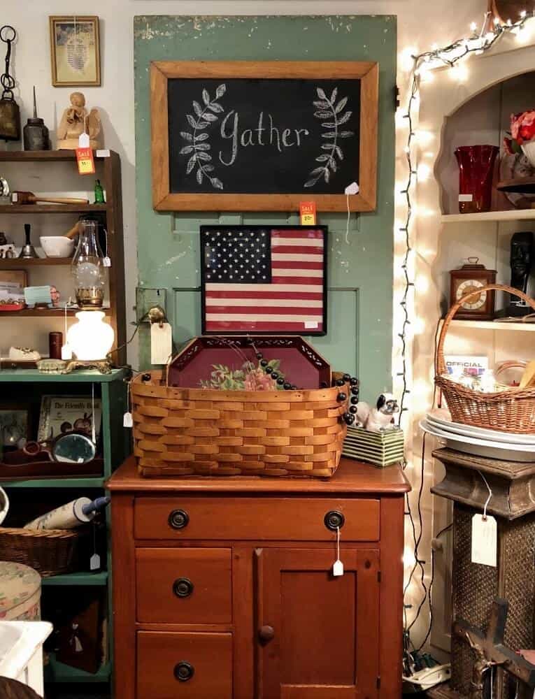 green door with brown dresser in front and flag hanging on it