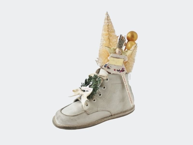Vintage white baby shoe decorated for baby's first christmas