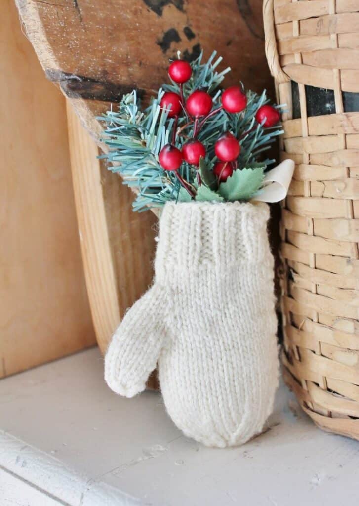 Antique mitten decorated with greenery and red berries