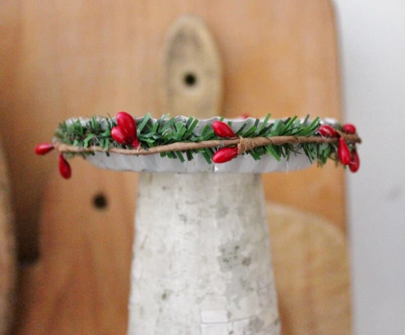 Decorating the side of the tart tin with pine and berry garland