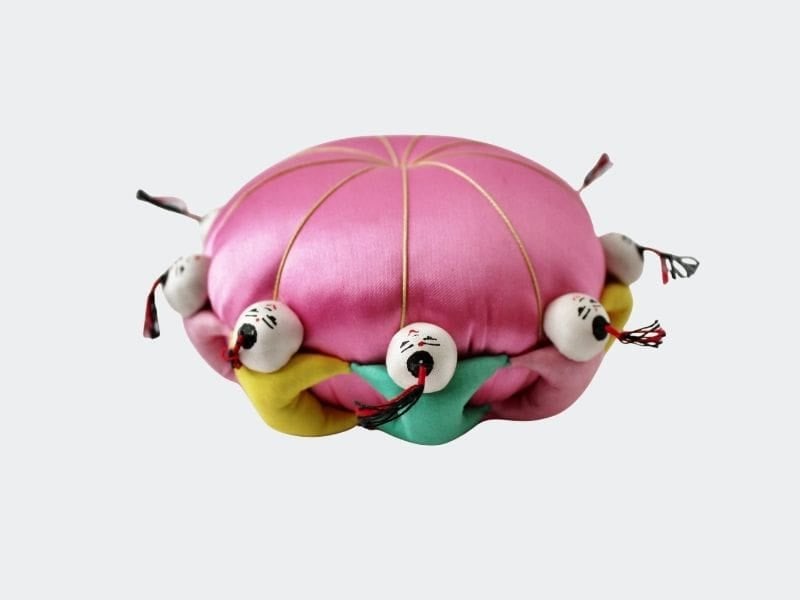 Pink silk pin cushion with Chinese figures around the edge