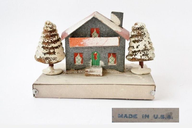 Gray putz house on large white base with two trees