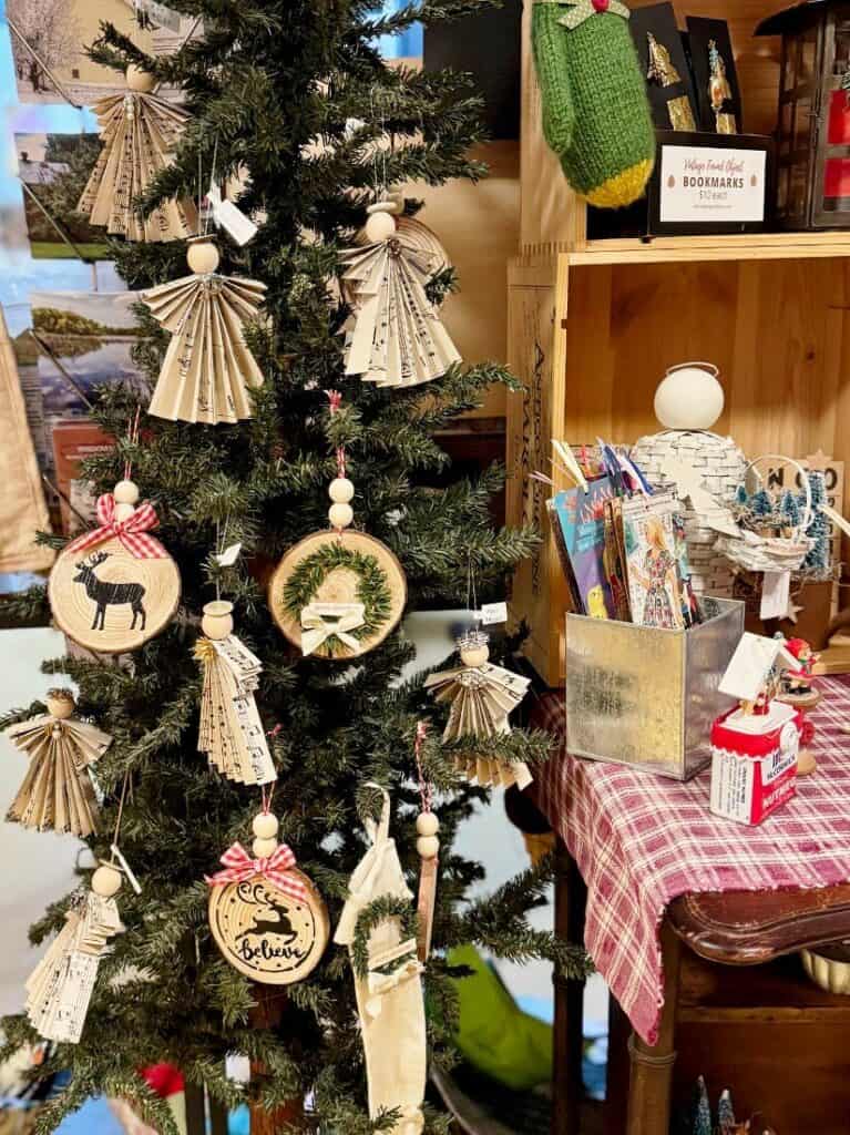 Several angels hanging on a tree at a craft show