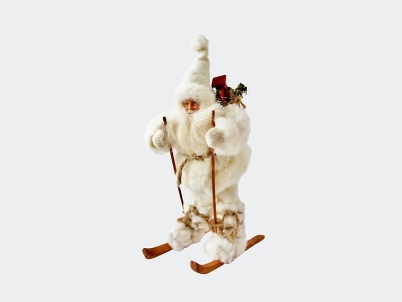 Santa in white outfit on skiis