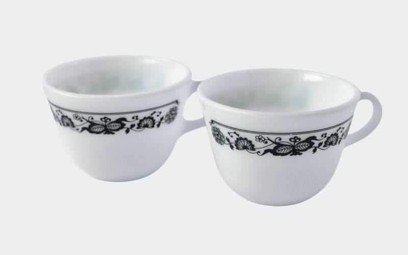 pair of white glass mugs with navy blue decoration around lip