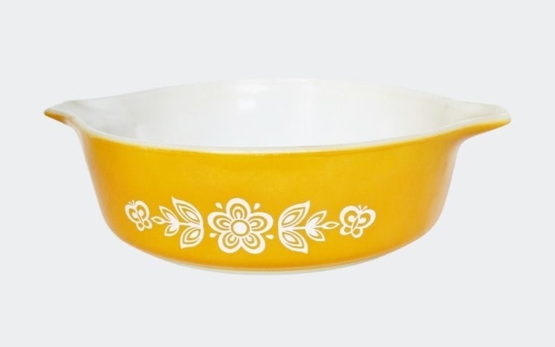 yellow caserole with white flower and butterfly decoration