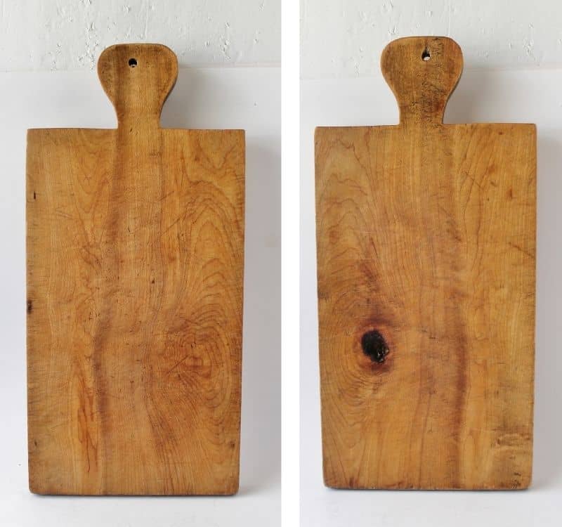 front and back of a vintage cutting board, one side with dark black spot
